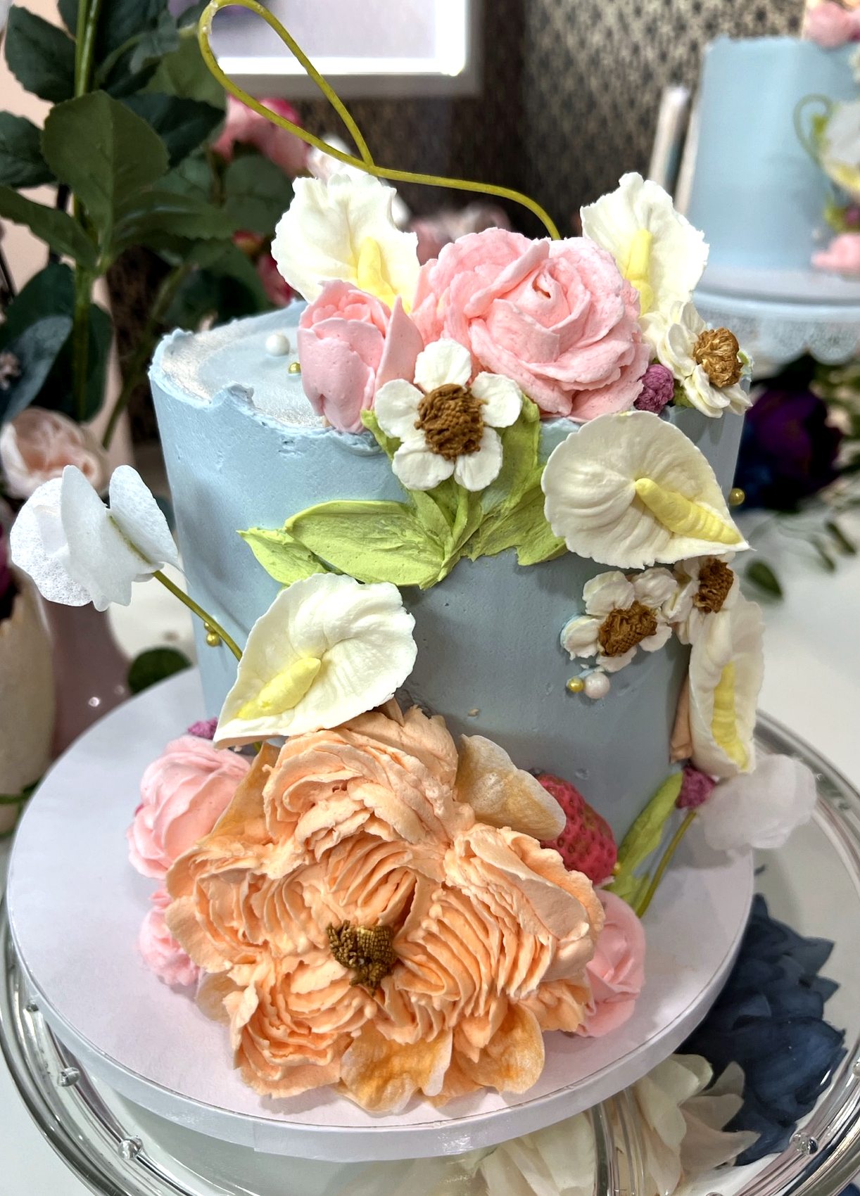 Tarta floral verde clara con ramillete de flores frescas y acabado moteado.
