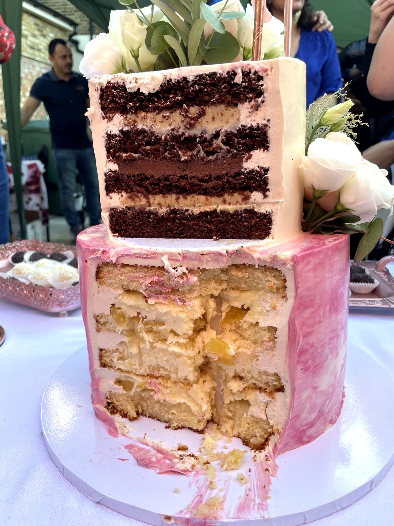 Detalle de corte de tarta con capas de chocolate, crema y relleno en porciones visibles.